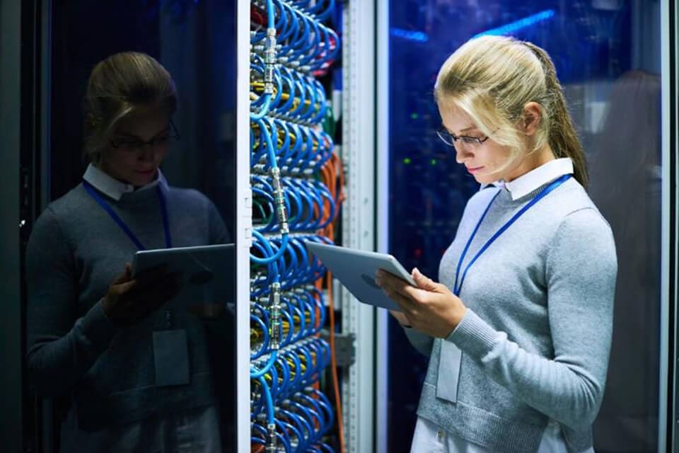 A woman is looking at her tablet in front of the server.